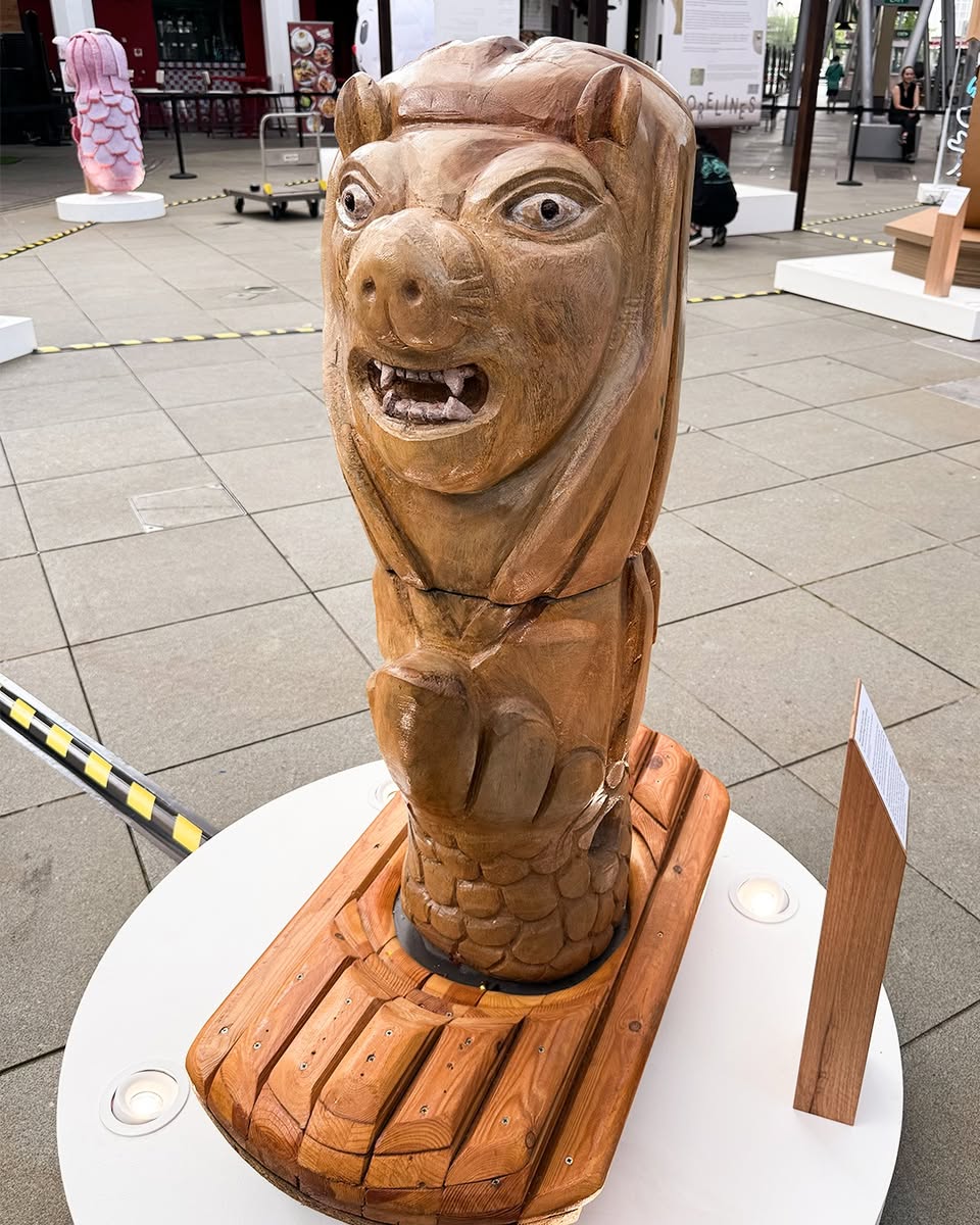 An outdoor art display featuring multiple Merlion variations.