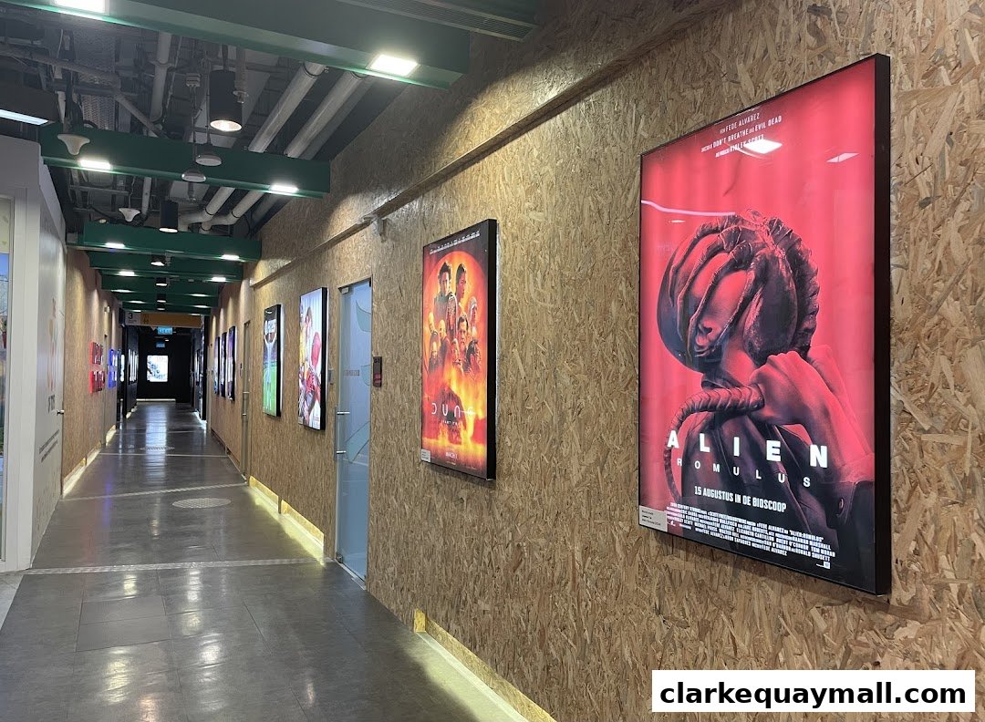 A hallway with movie posters on a wood-paneled wall, leading to an exit sign.