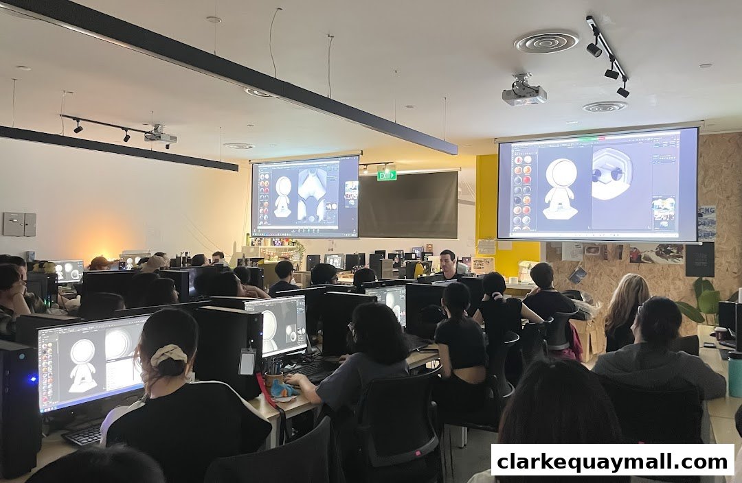 Students in a classroom learning 3D modeling on computers with instructor.