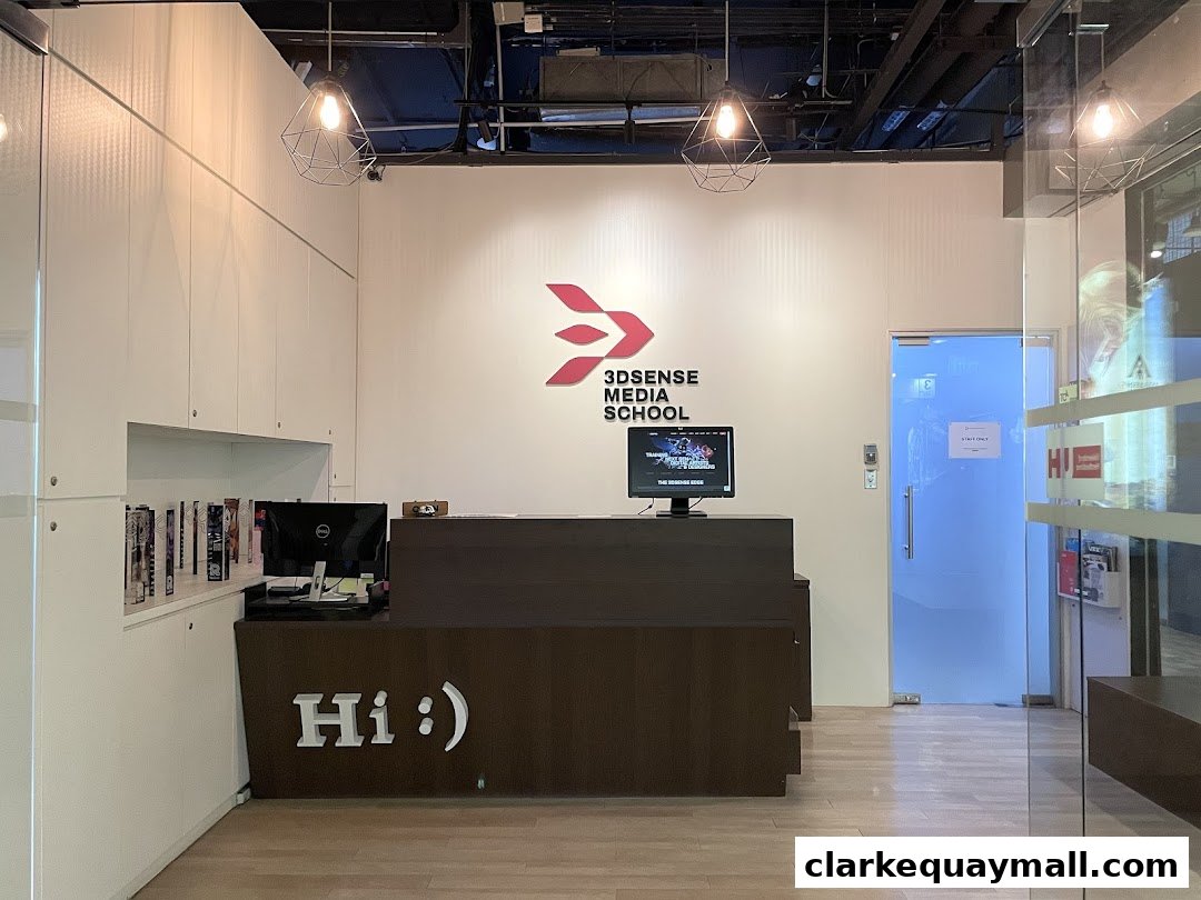 The reception area of 3dsense Media School with a desk, computers, and school logo.