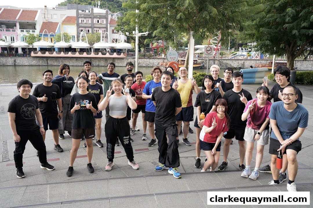 A diverse group of young adults posing for a photo by a river with colorful buildings in the background.