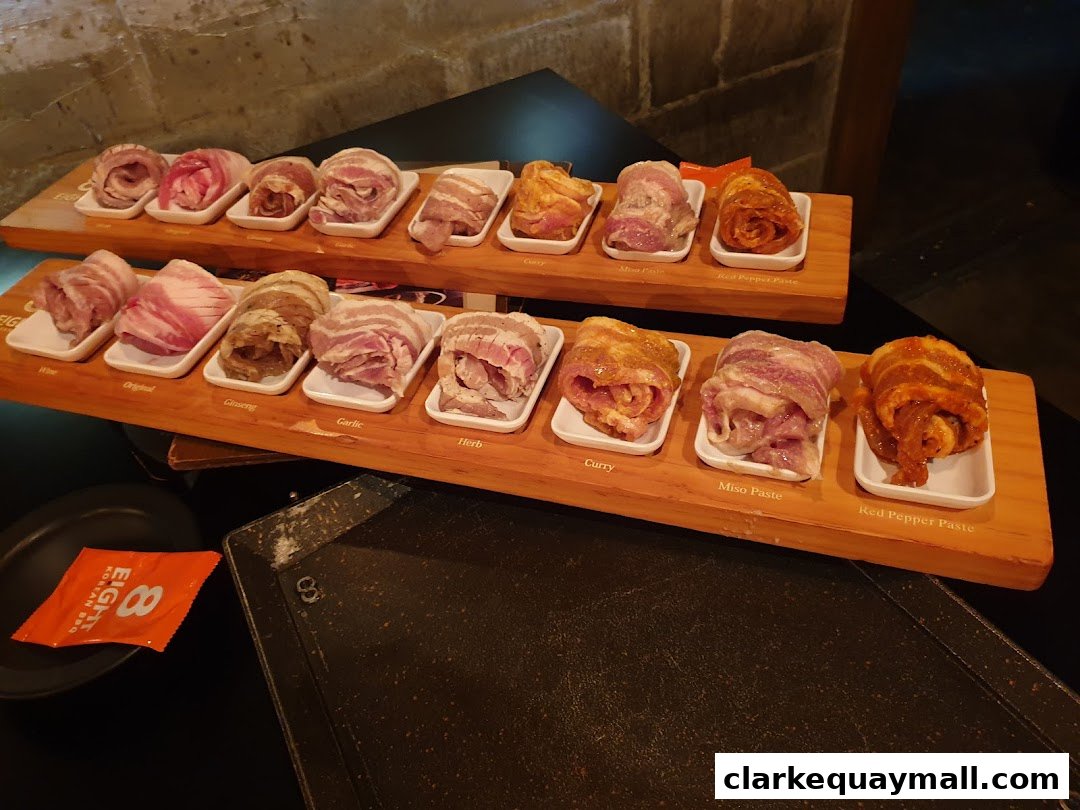 A selection of marinated Korean BBQ meats presented on wooden platters.