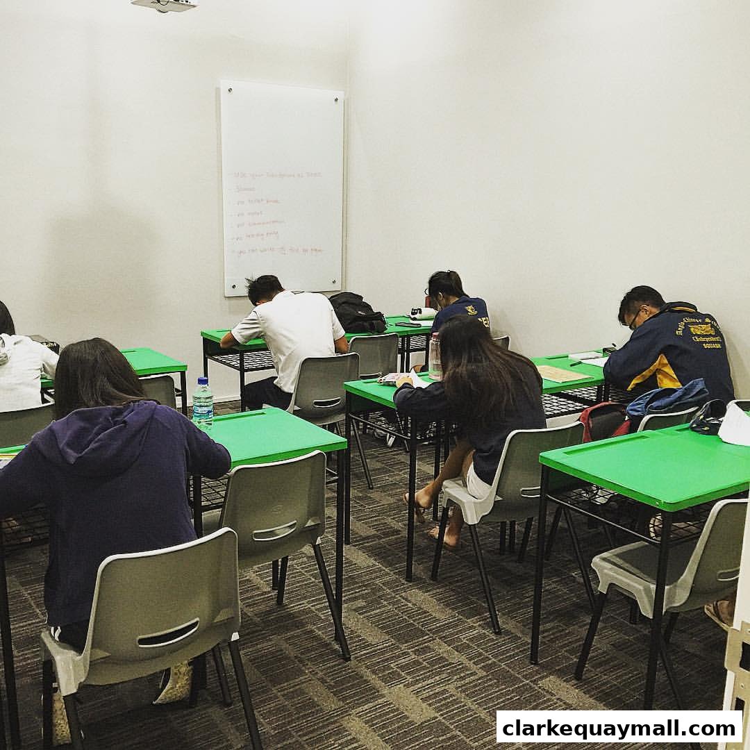 Students are seated at desks in a classroom, focused on their work.