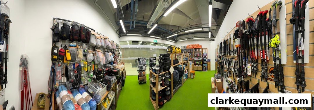 Interior view of an outdoor adventure gear shop, showcasing trekking poles, bags, and accessories.