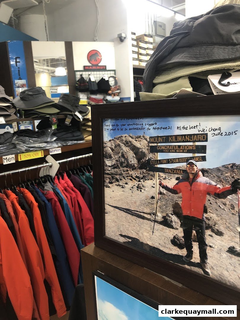 A retail store interior displaying outdoor apparel and a framed photo of a Kilimanjaro summit.