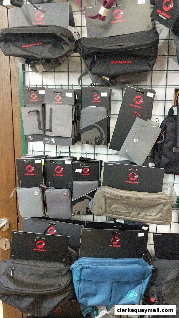 A display of various Mammut brand bags and accessories, including waist bags and wallets.