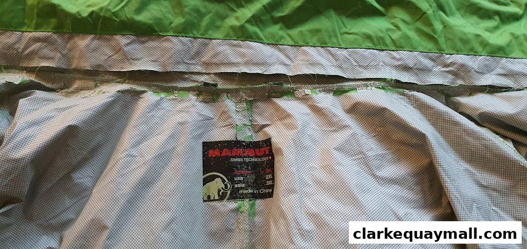 Close-up of a green jacket's interior label showing brand and size information.