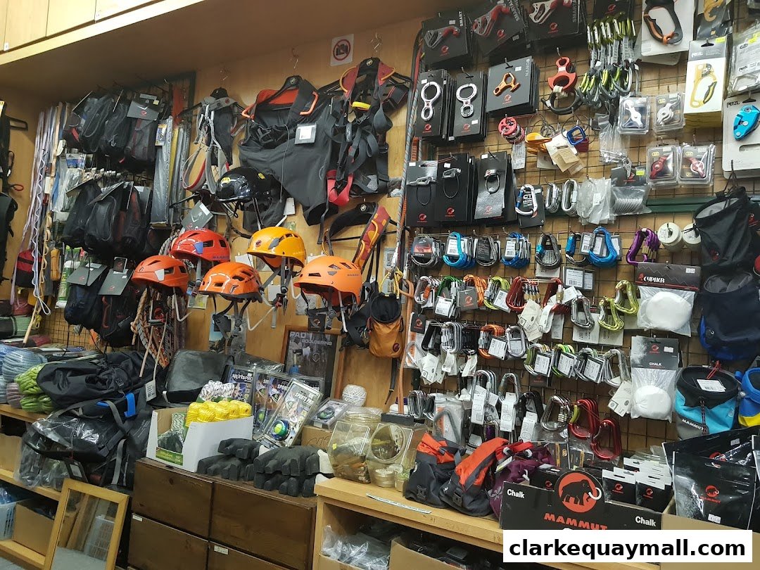 A retail shop interior displaying climbing and mountaineering gear, including helmets, ropes, and carabiners.