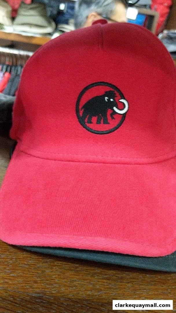 A close-up of a red baseball cap with the Mammut logo embroidered on the front.