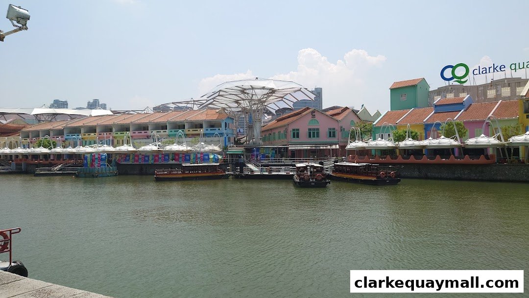 A scenic view of Clarke Quay Singapore with colorful buildings and boats on the river.
