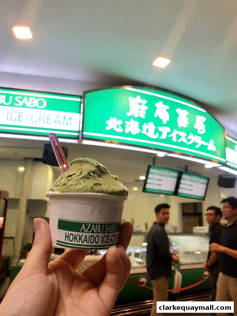 A hand holds a cup of green tea ice cream from Azabu Sabo.