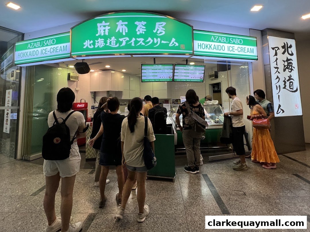 People queuing at Azabu Sabo Hokkaido Ice-Cream shop with green signage.