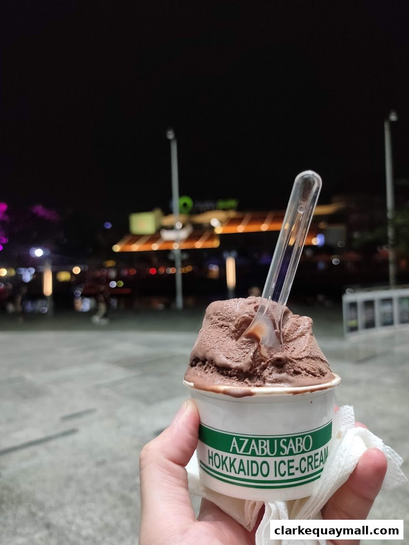 A hand holds a cup of chocolate ice cream from Azabu Sabo Hokkaido Ice-Cream.
