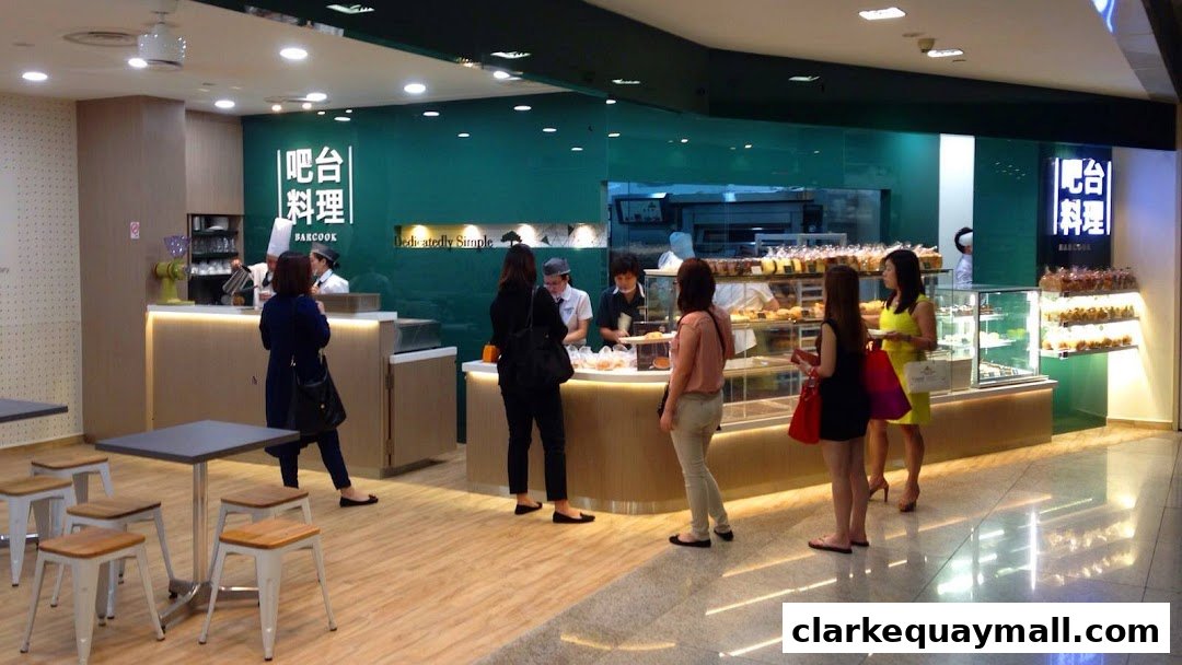 Customers are served at a bakery counter with a display of baked goods.