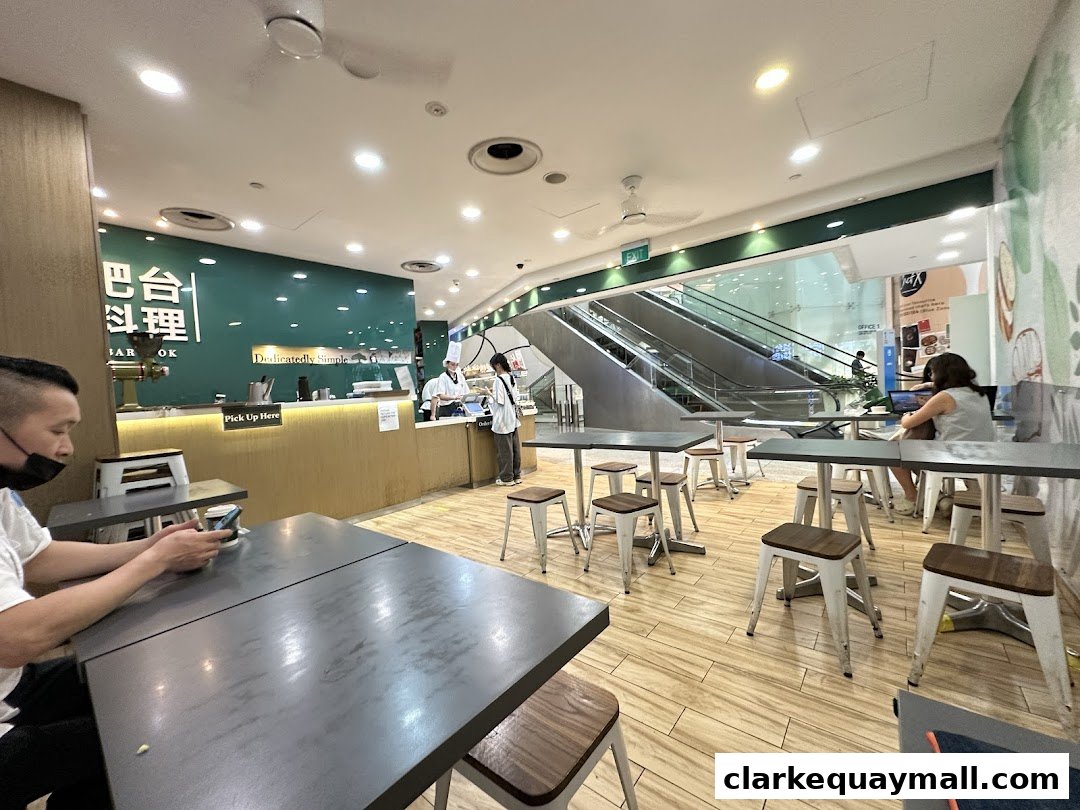 Interior view of Barcook Bakery with seating, counter, and escalators in the background.