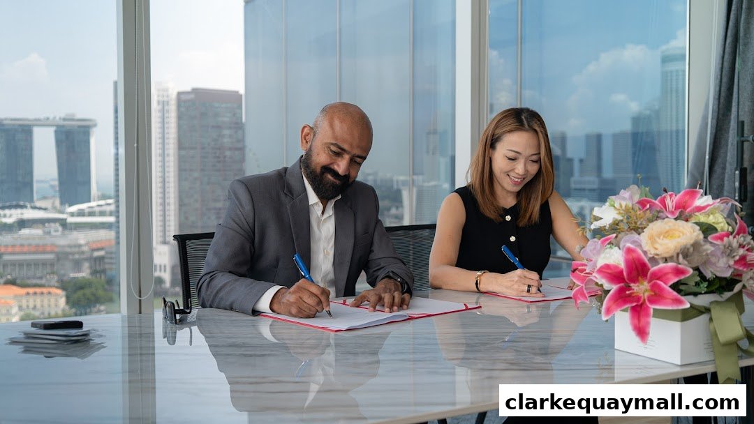 Two professionals signing documents at a table with a city view.