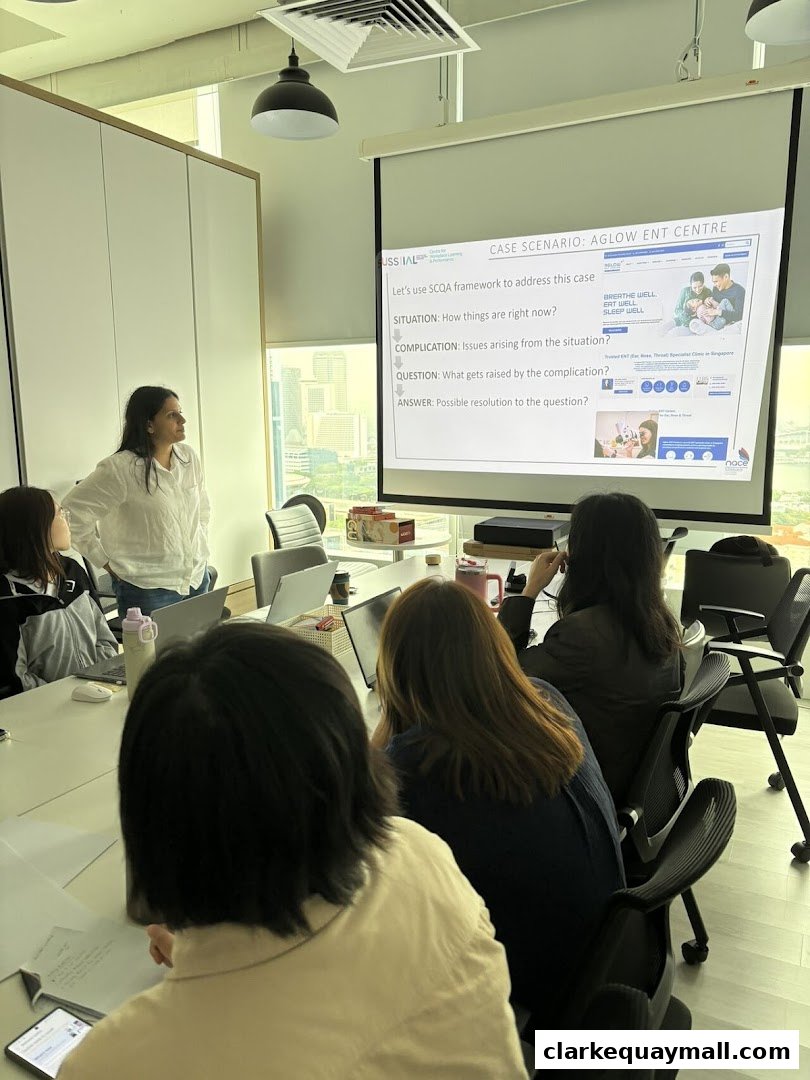 A presenter leads a case study discussion in a modern meeting room with a projector screen.