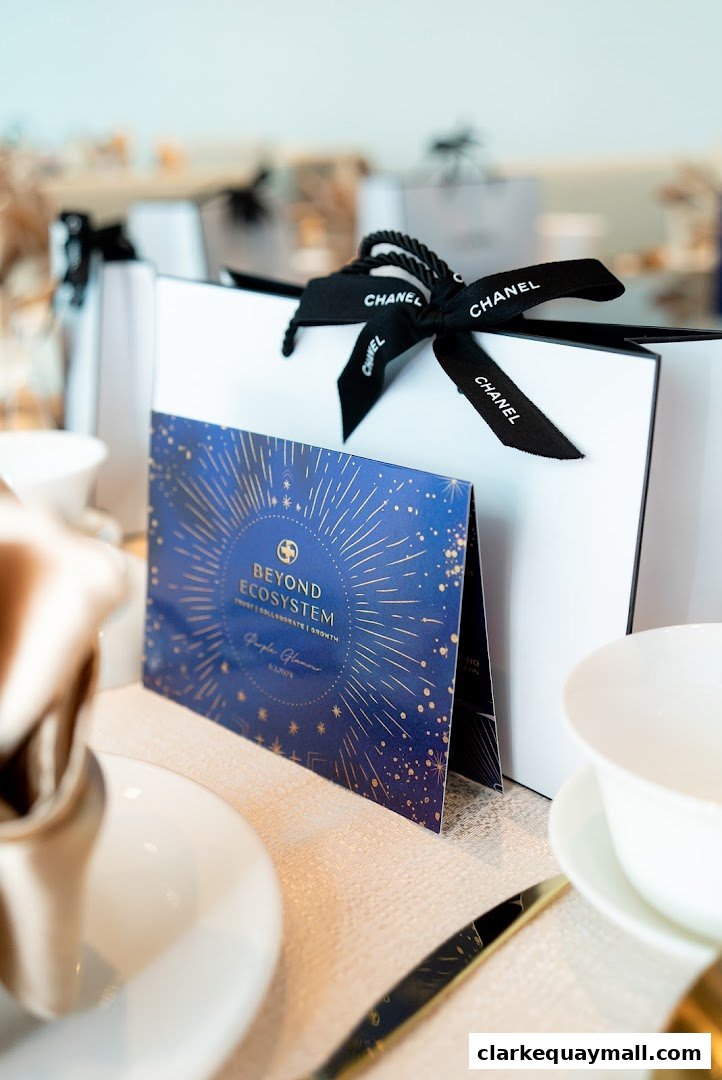 Chanel gift bags and a 'Beyond Ecosystem' card on a table setting.