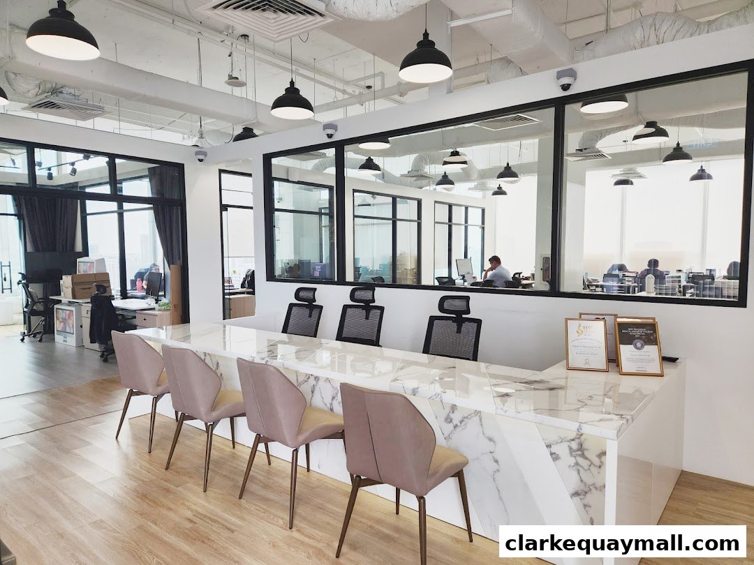 Modern office reception area with marble counter, chairs, and view into work areas.