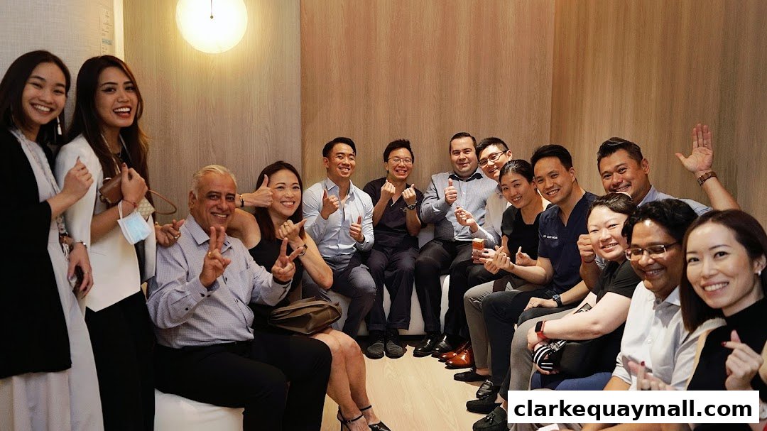 A diverse group of smiling people, likely staff, posing for a photo indoors.