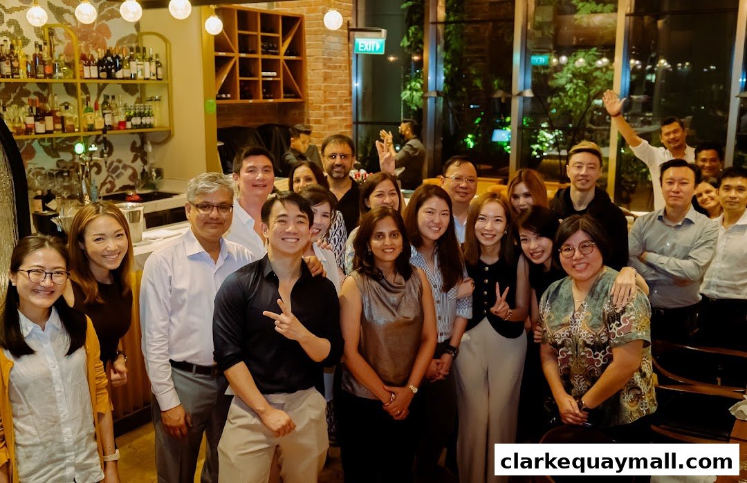A diverse group of people posing for a photo in a well-lit restaurant or bar.