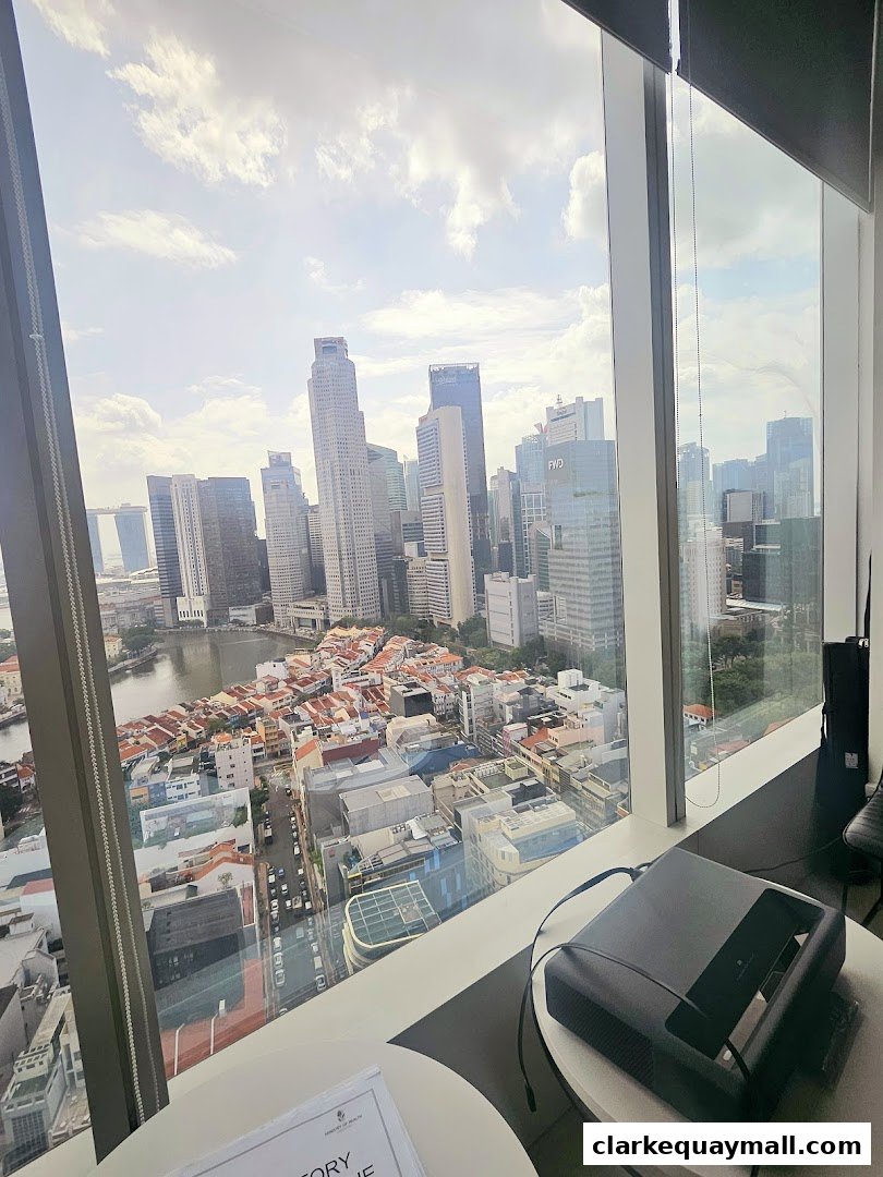 View of a city skyline from a high-rise window with a projector on a table.