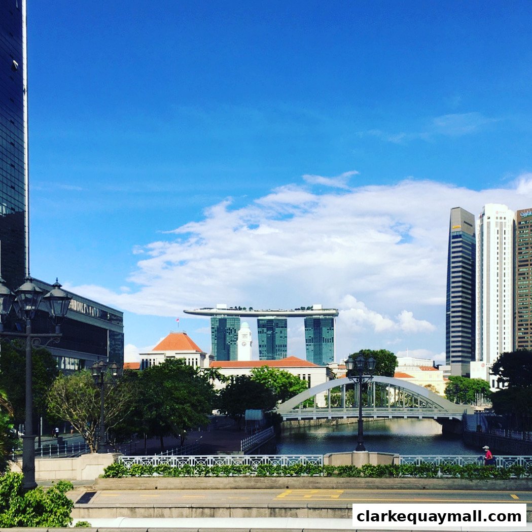 Singapore skyline featuring Marina Bay Sands and a bridge over the river.