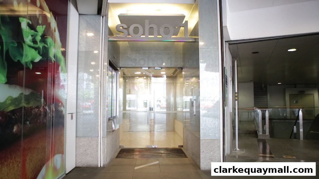 The entrance to a building with a large burger advertisement on the left and the sign 'soho1' above the doors.