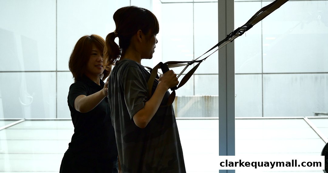 A trainer assists a client with a suspension training workout.