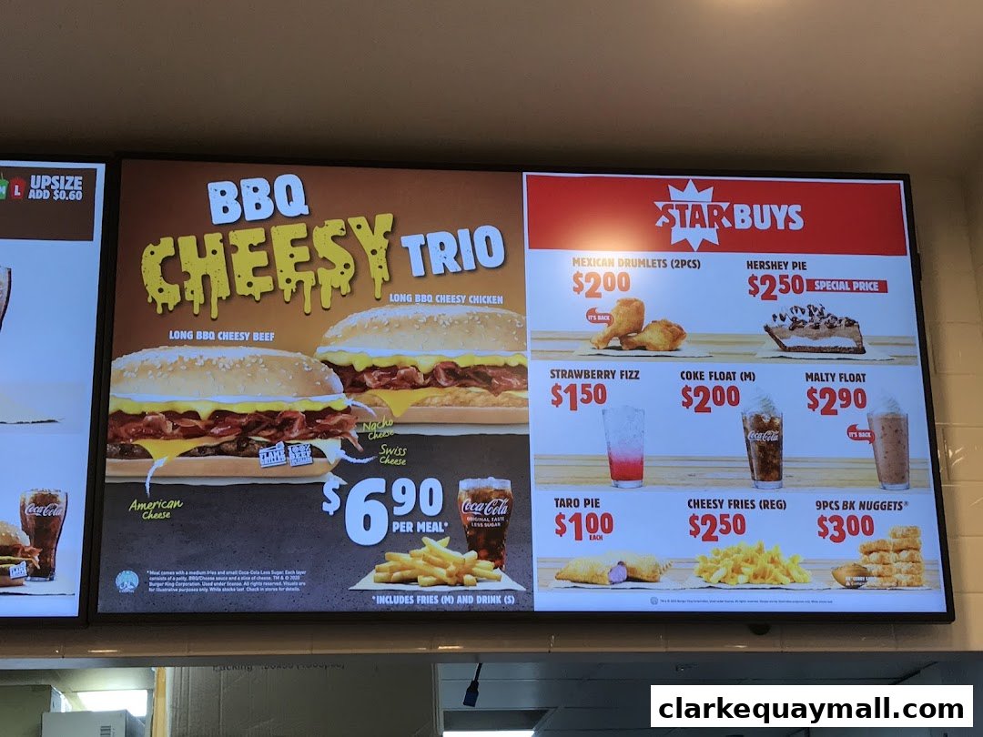A digital menu board displaying Burger King's BBQ Cheesy Trio and Star Buys.