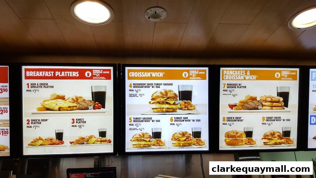 A digital menu board displaying various breakfast platters and sandwiches from Burger King.