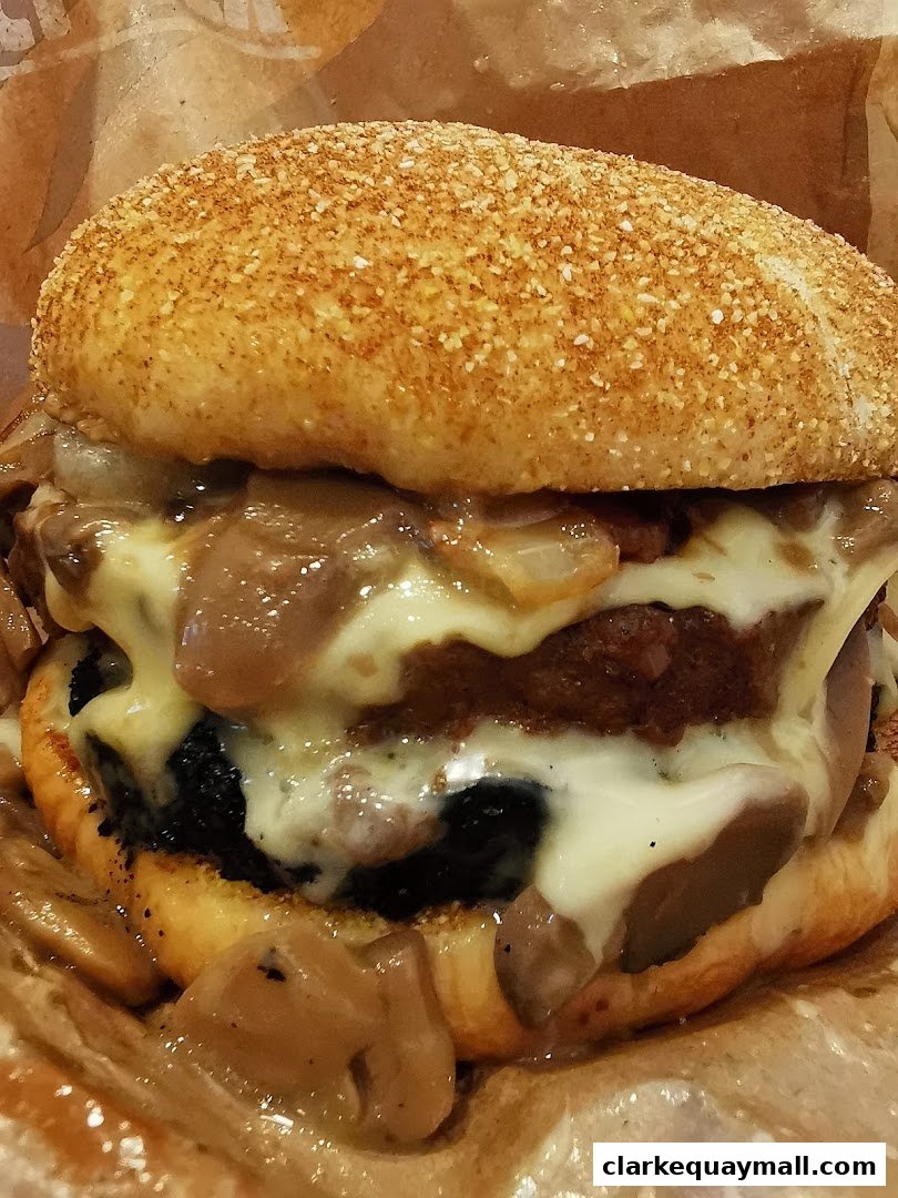 A close-up shot of a juicy burger with melted cheese and mushrooms.