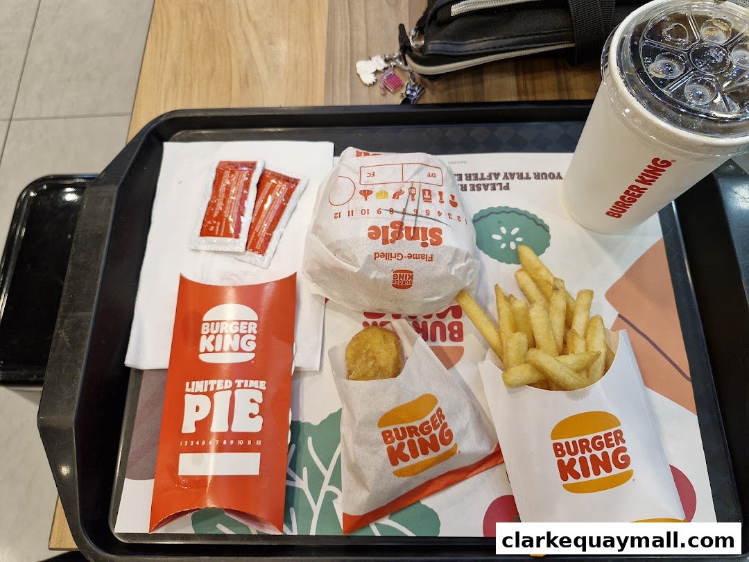 A tray of Burger King food including a burger, fries, a drink, and a limited time pie.