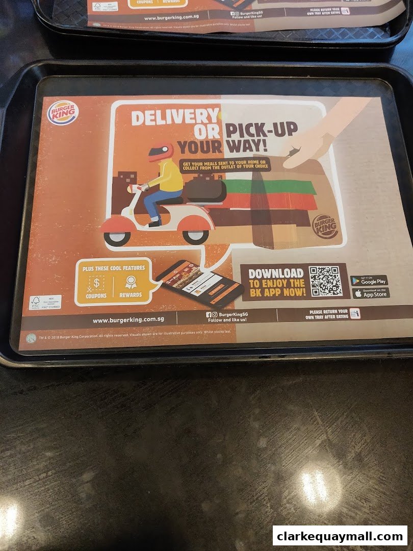 A Burger King placemat promoting delivery and pick-up options, with app download information.