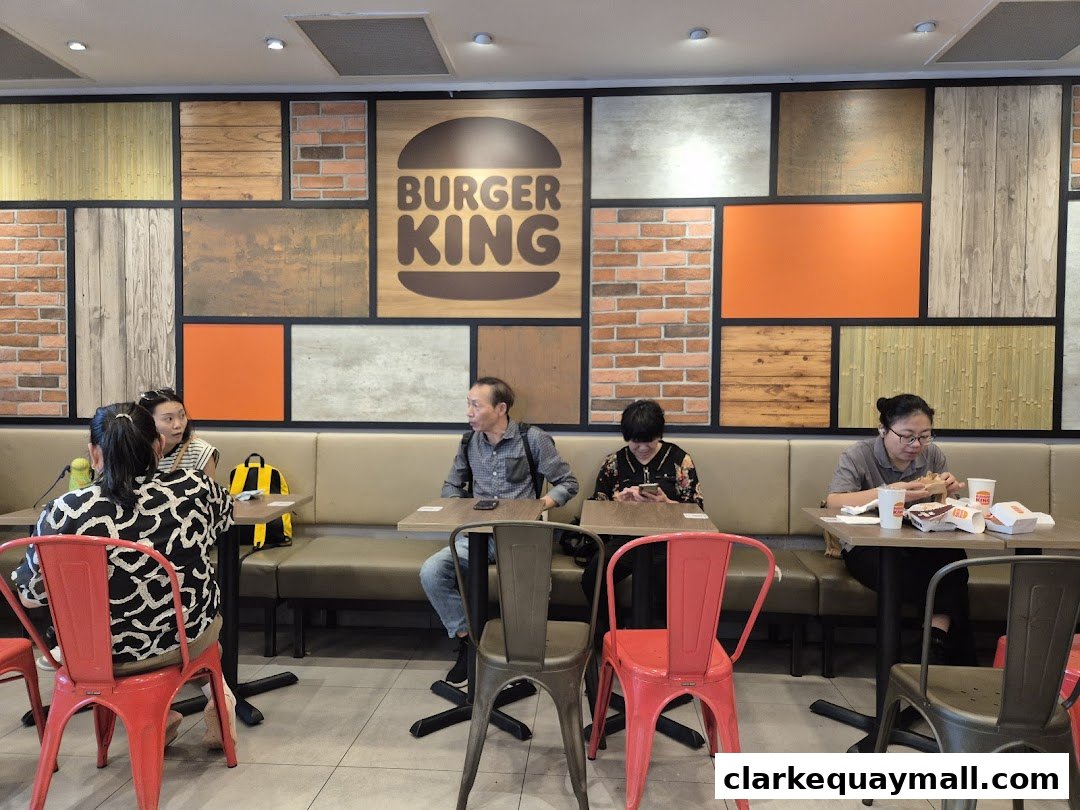 People dining at Burger King with a distinctive wall featuring the brand logo and various textures.