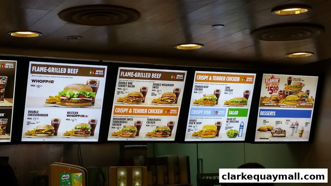 A digital menu board displaying various Burger King meals, including burgers, chicken, fish, and desserts.