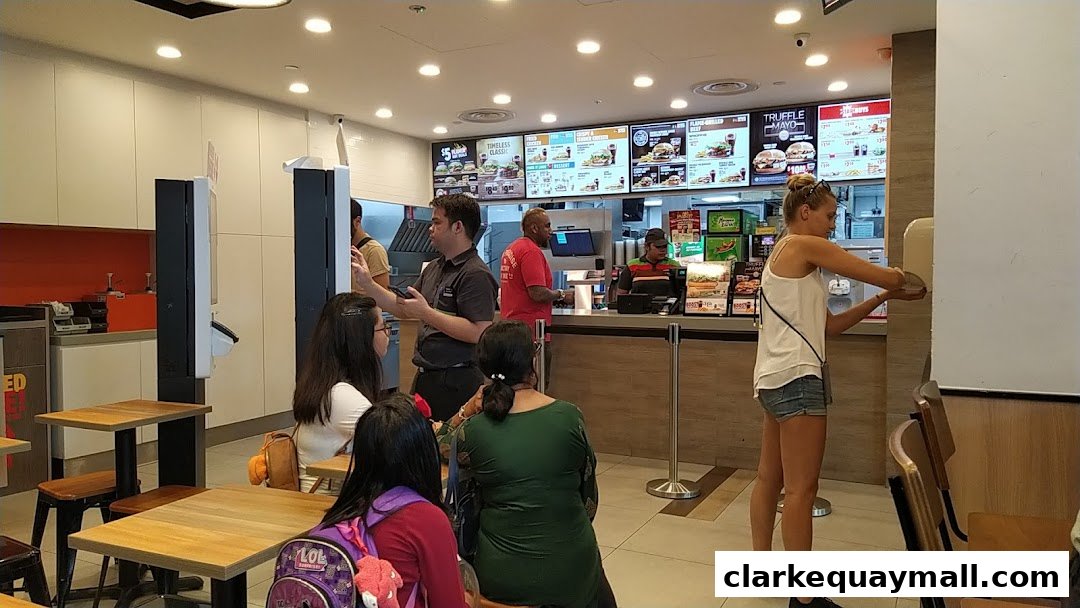 Customers ordering food at the counter of a Burger King restaurant.