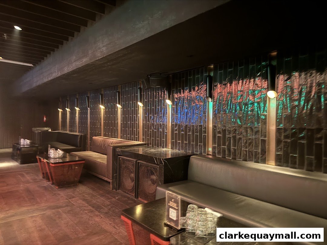 Interior view of a stylish lounge with plush seating, modern lighting, and a tiled accent wall.