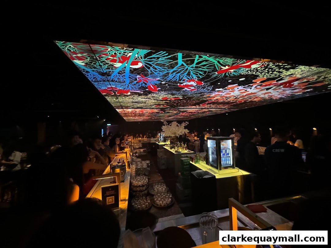 Interior of a dimly lit bar with a vibrant, illuminated ceiling and patrons at the bar.