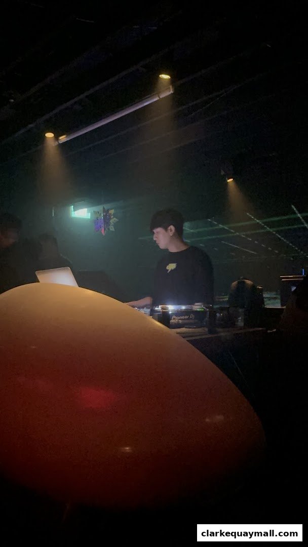 A DJ plays music at Capital Zouk Singapore with laser lights and spotlights.