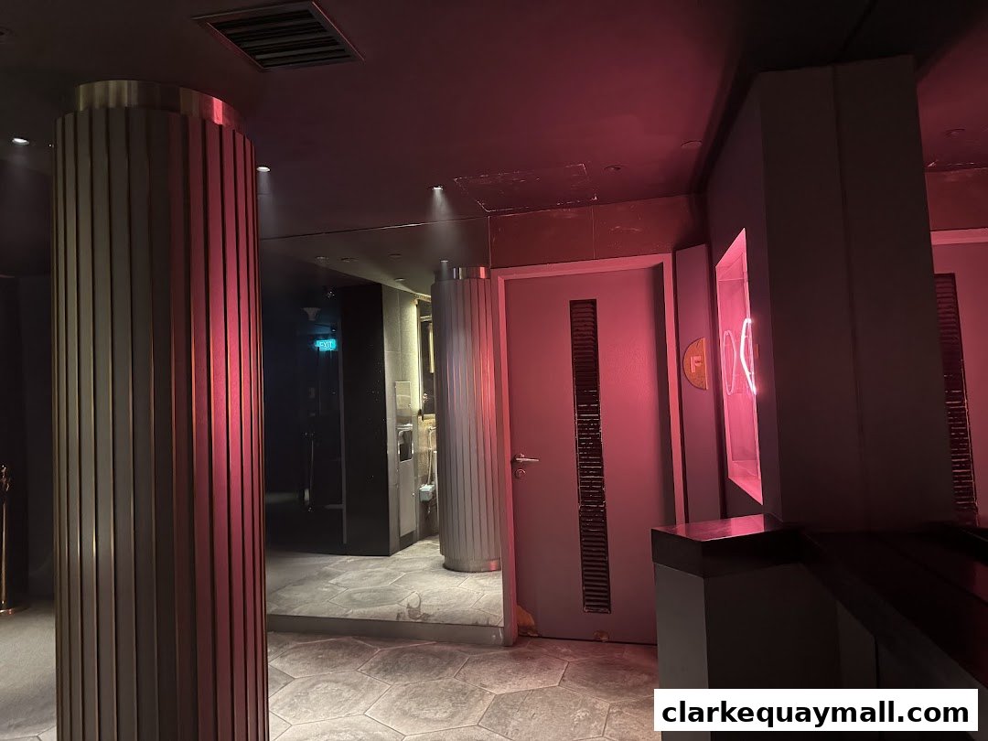 Interior view of Capital Zouk Singapore with modern pillars and pink neon lighting.