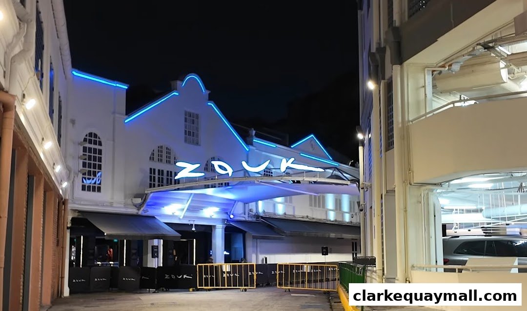 The illuminated Zouk Singapore building at night with blue neon lights and a covered entrance.