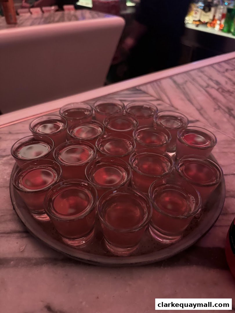 A tray of red shots is presented on a marble counter at Capital Zouk Singapore.