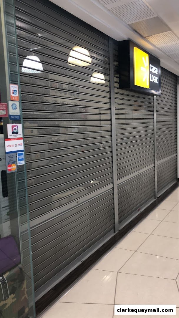 The closed Case Logic shop front with its illuminated sign and security shutters down.