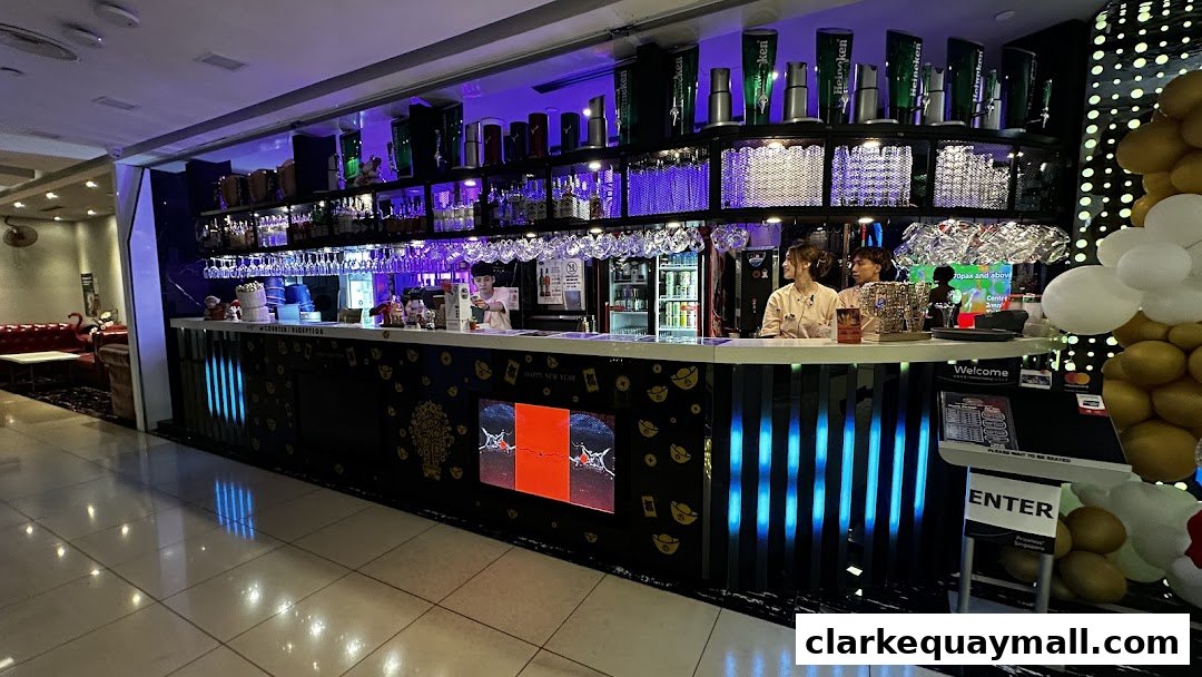 A modern bar with staff serving drinks and a seating area with plush sofas.