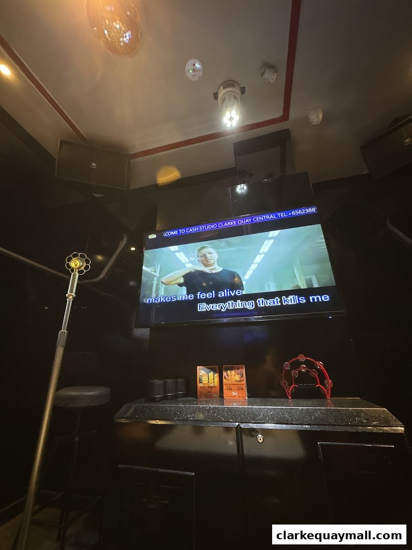 Interior of a karaoke room with a large screen displaying lyrics and a disco ball.