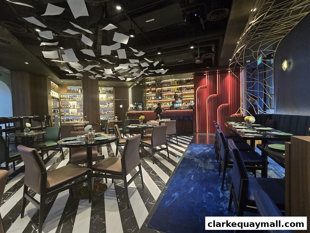 Interior of a stylish restaurant with a bar, tables, and unique ceiling decor.