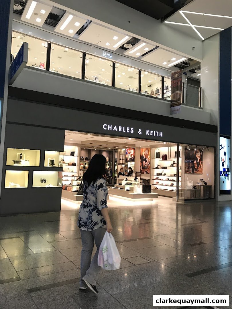 A woman walks past the Charles & Keith store, showcasing stylish footwear and handbags.