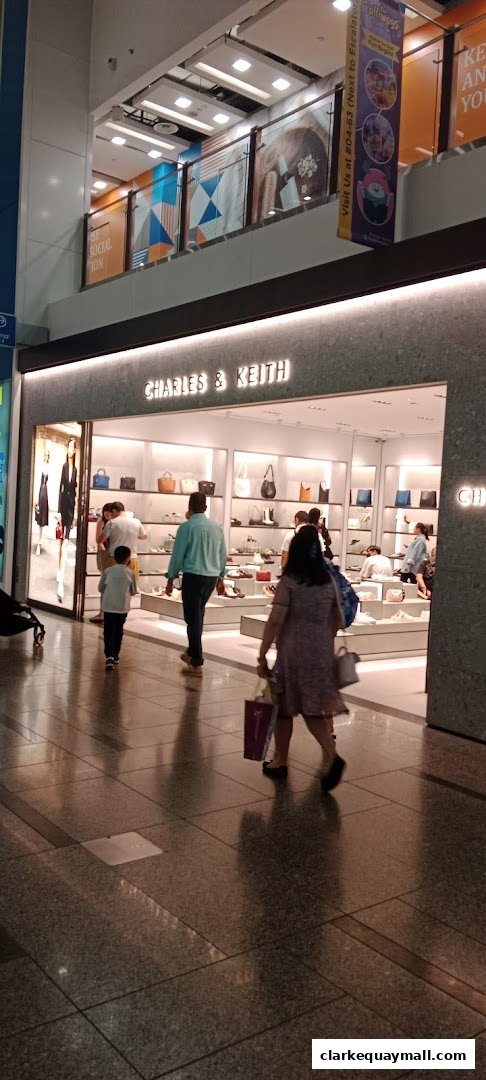 The Charles & Keith store entrance with displays of handbags and shoes, and shoppers entering.