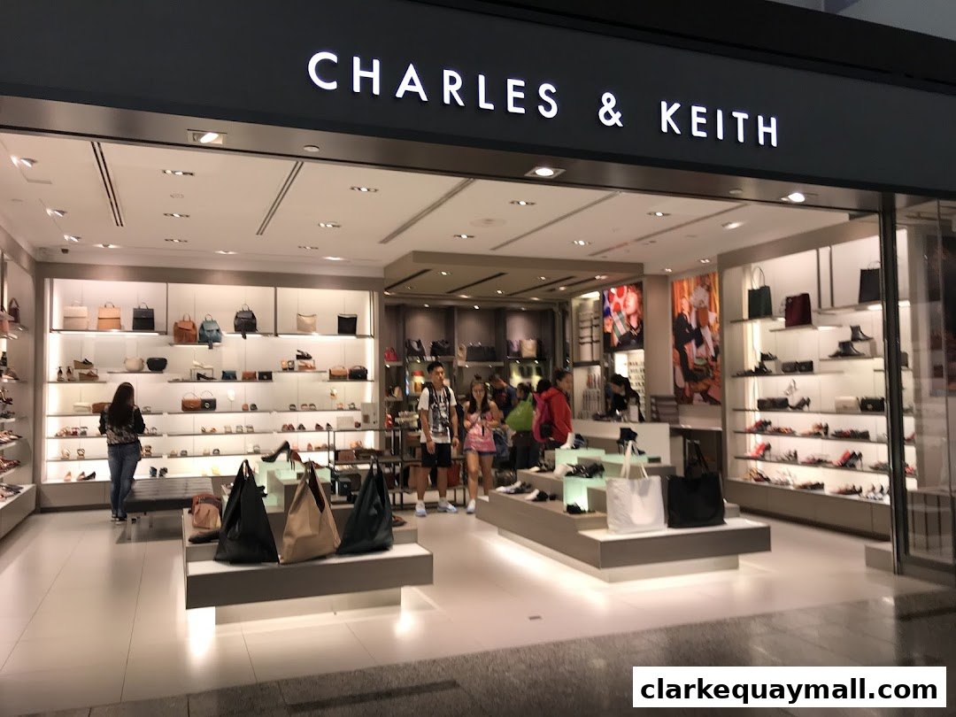 The CHARLES & KEITH shop displays a wide selection of stylish handbags and shoes on illuminated shelves.